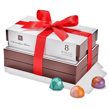 Essential Holiday Gift Tower tied with red ribbon